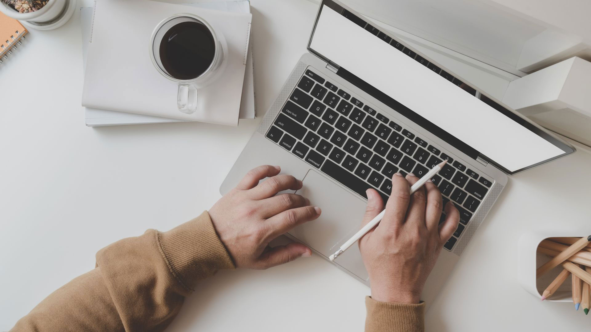 top down image of a corporate Worker on laptop with a coffee